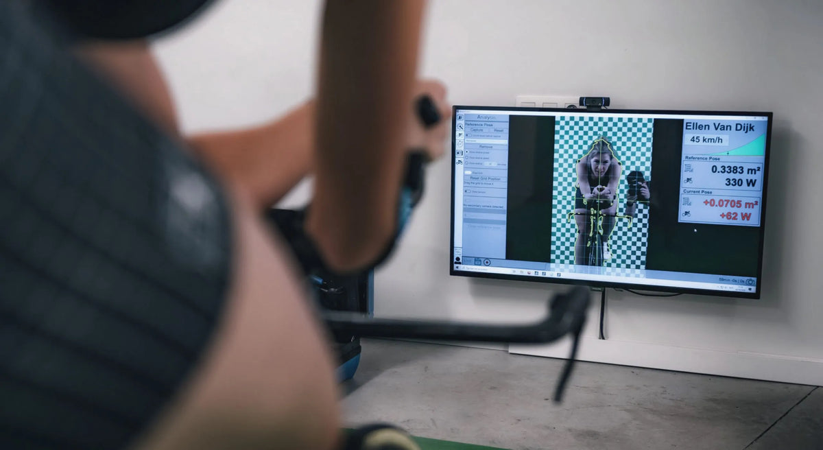 Indoor aero testing session at Bioracer Speedcenter with Ellen Van Dijk, showing aerodynamic data and frontal area analysis on screen during a time trial position fit.